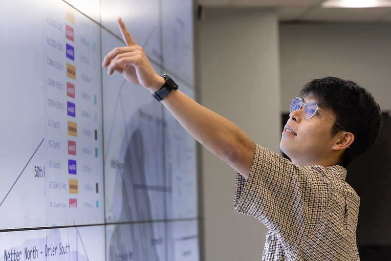 Kawakami pointing at large presentation display.