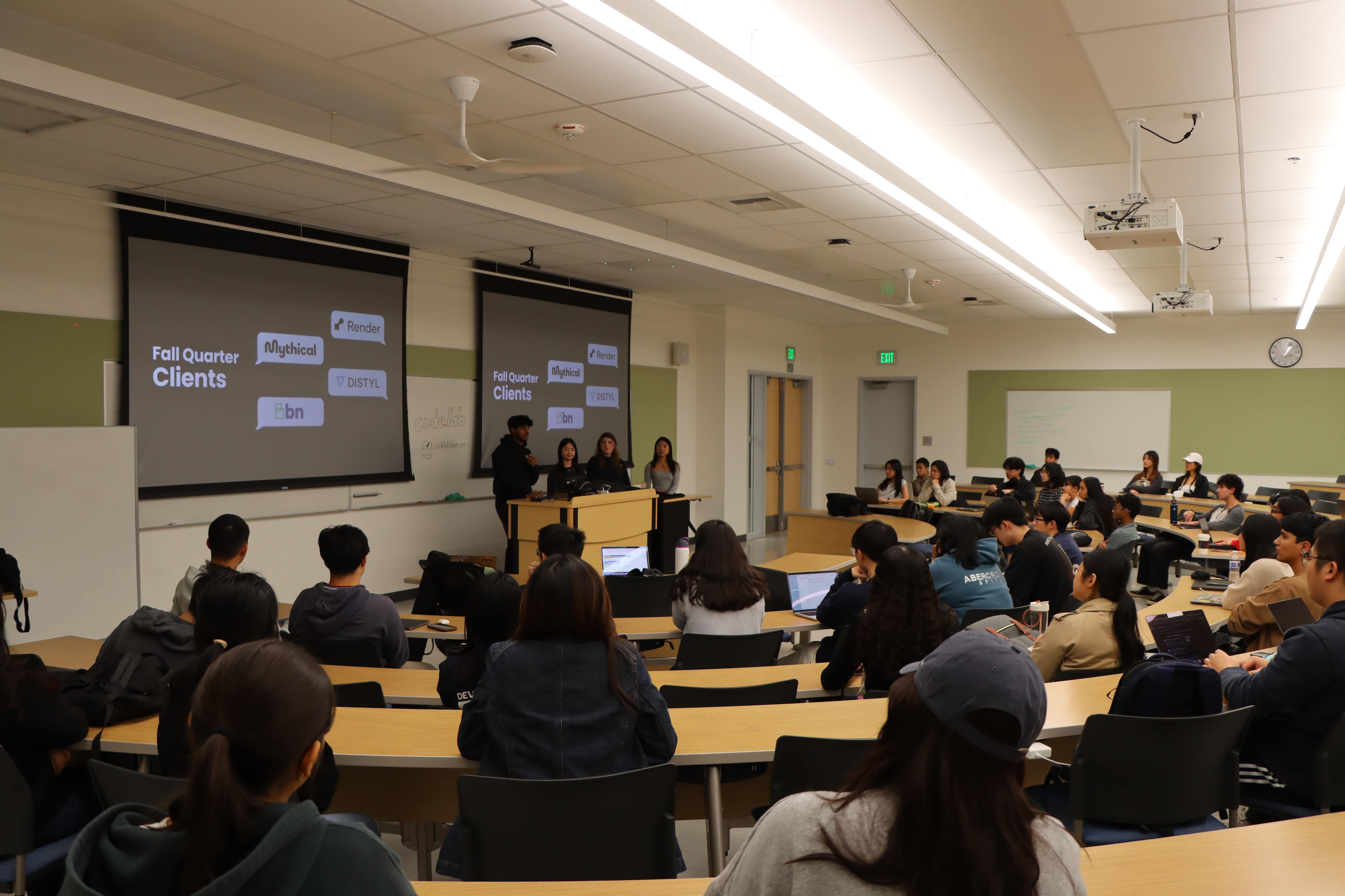Many students at tables watching Codelab presenters