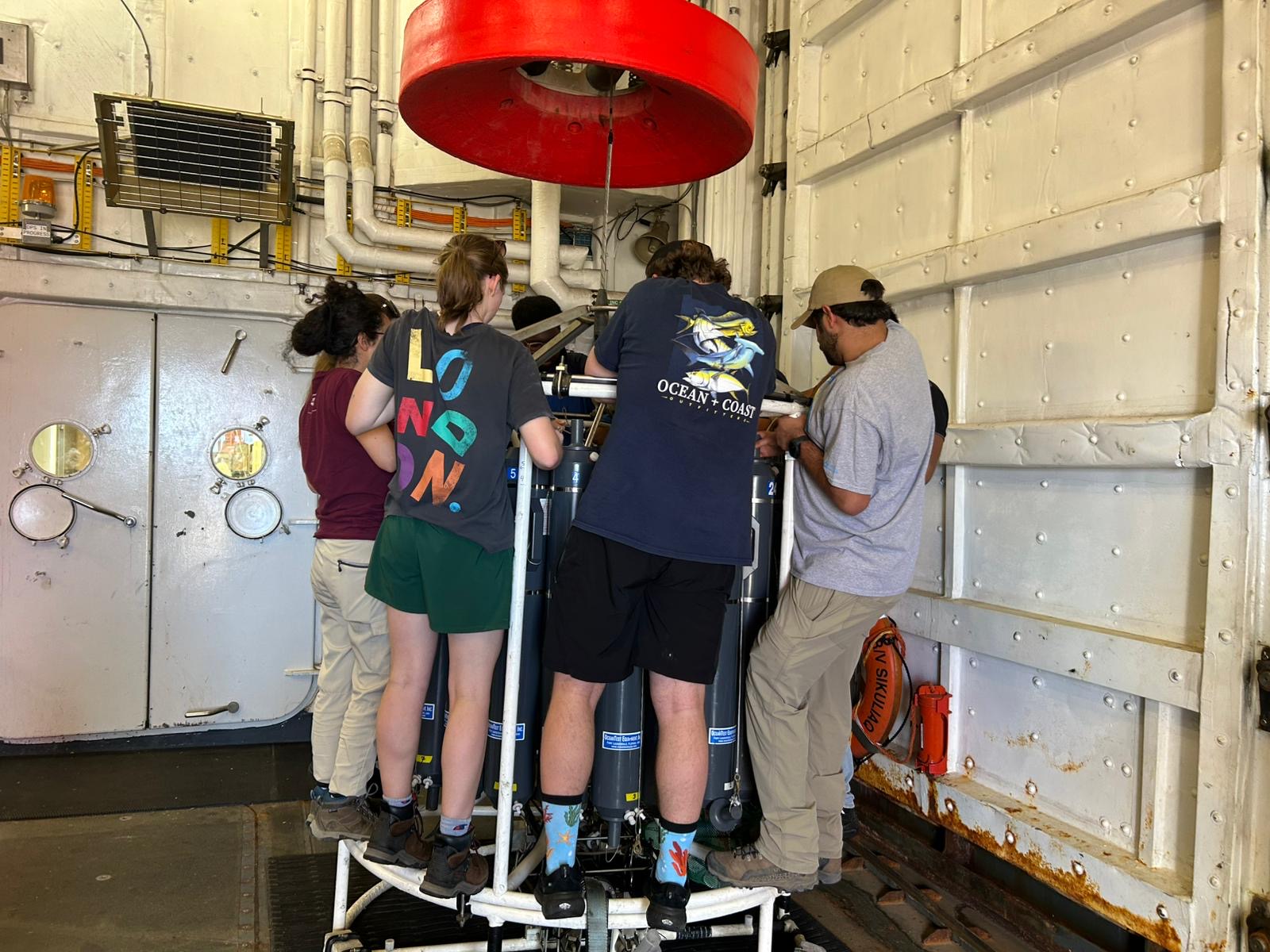 Students gather around a device 